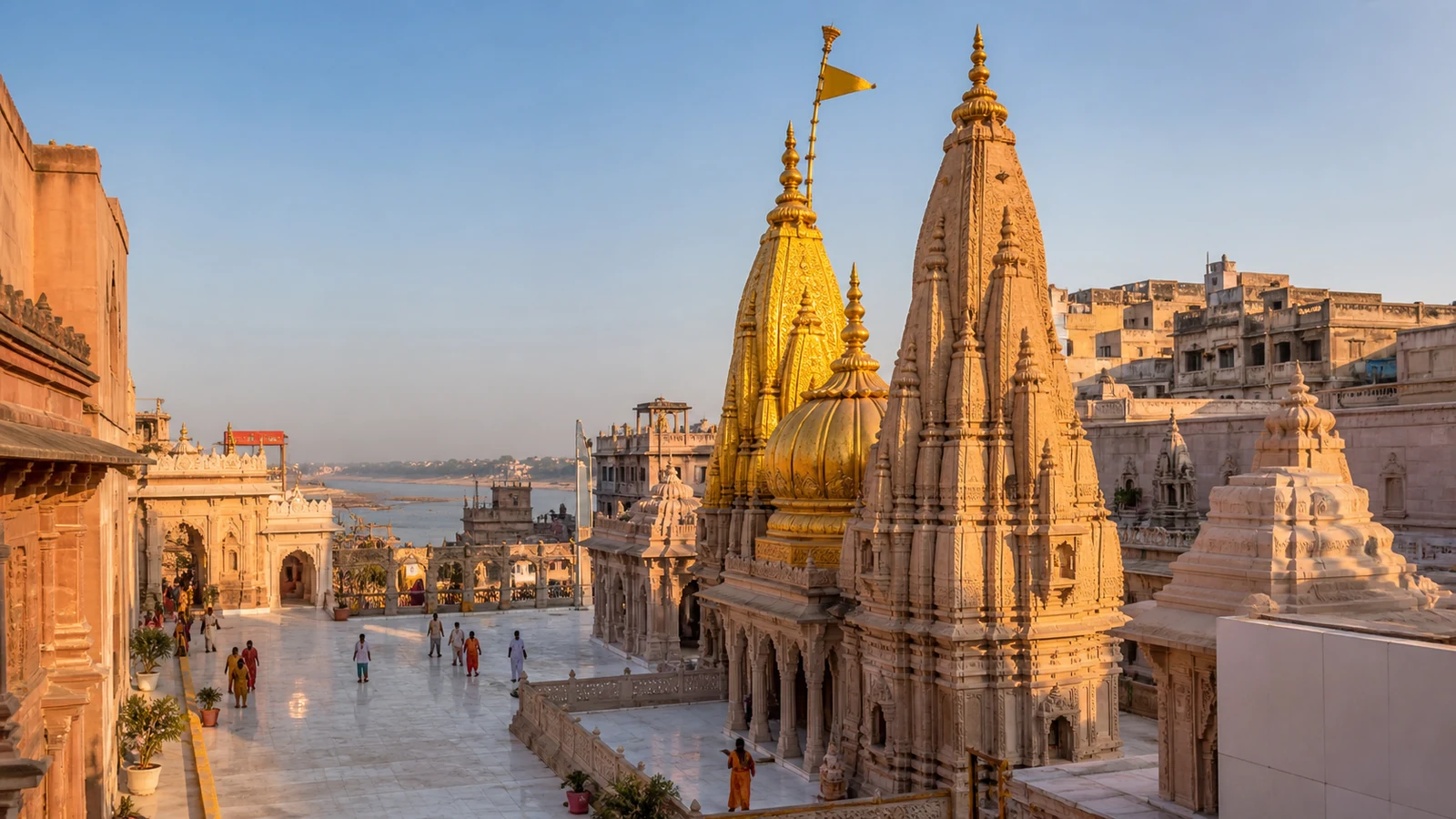 Shri Kashi Vishwanath Temple in Varanasi, with golden spires and the Ganga visible near the temple corridor.