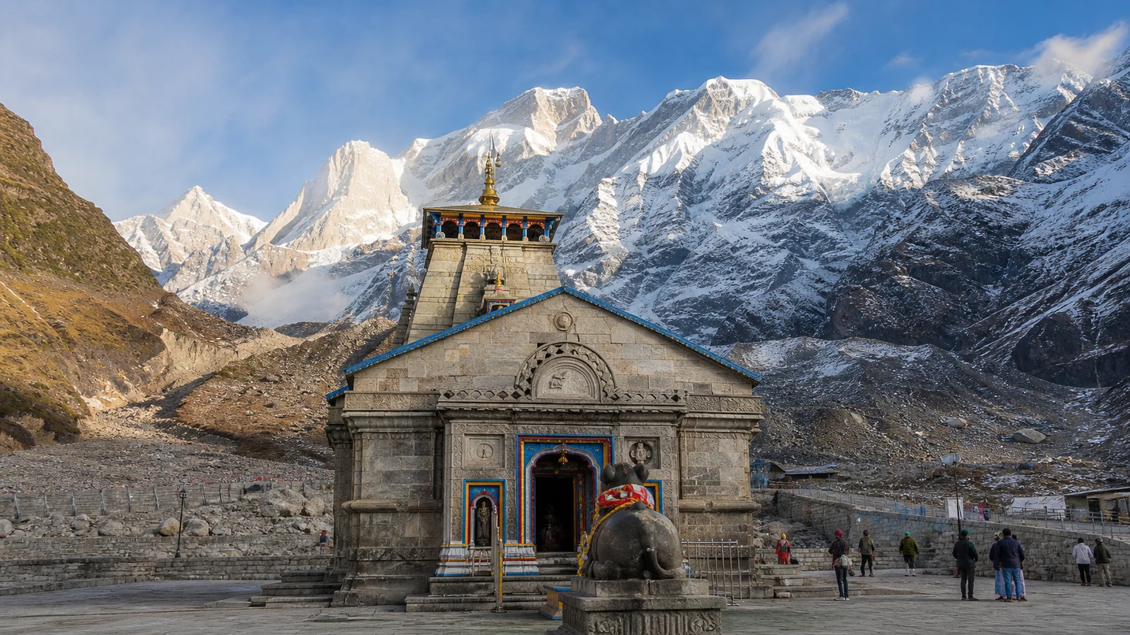 Kedarnath Jyotirlinga Temple in Uttarakhand, with Nandi in the stone courtyard and snow-covered Himalayan peaks behind.